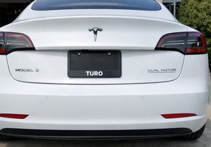 White Tesla photographed from behind on a driveway