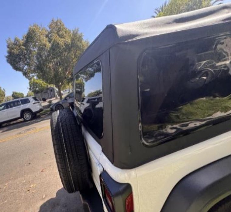 Driver side of the Jeep with the spare on the tailgate